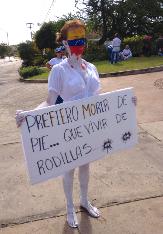 Painted Anti-Maduro Protester Holding Sign; Venezuala, February 2014