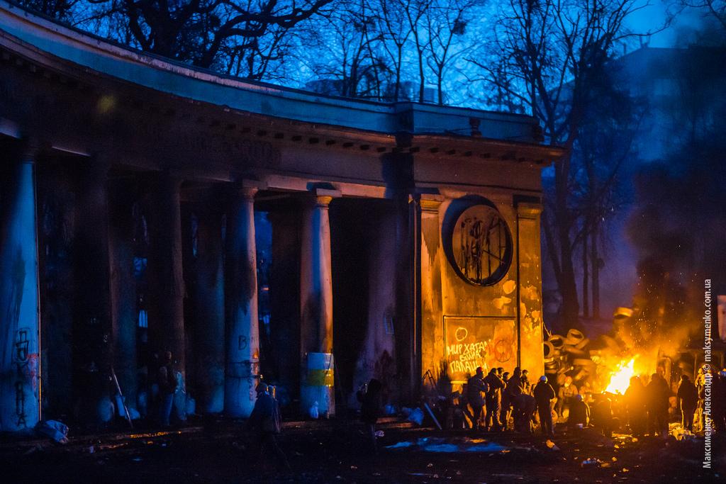 Protesters keep warm by a tire fire